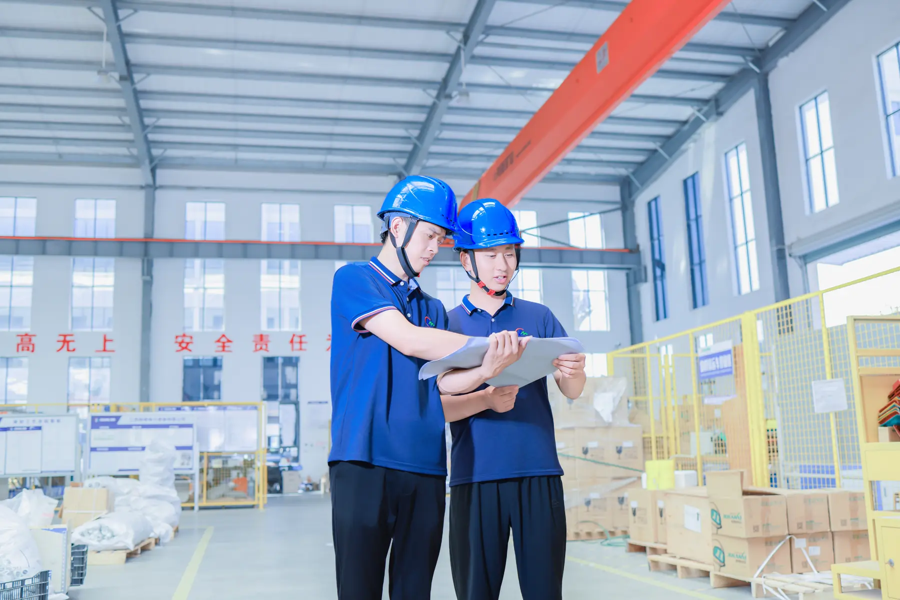 Minglang staff in safety helmets reviewing production documents