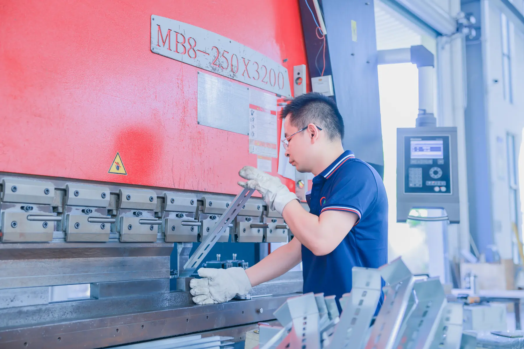 Minglang employee operating sheet-metal bending equipment